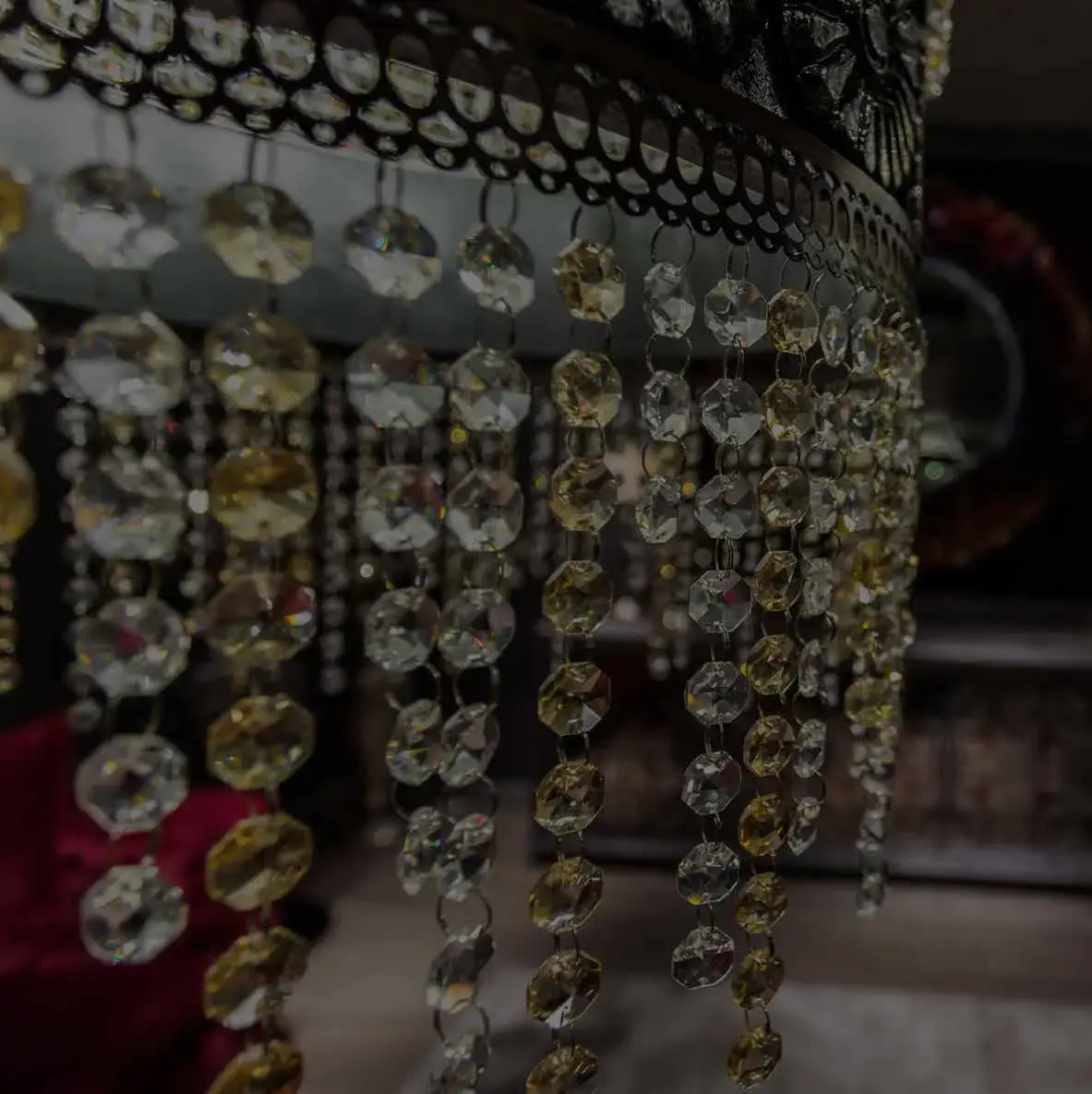 Detail of hanging crystal strands on a chandelier, lit from within